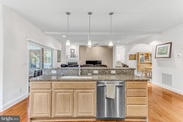 kitchen featuring light brown cabinetry, a kitchen island with sink, light hardwood / wood-style floors, stainless steel dishwasher, and ceiling fan