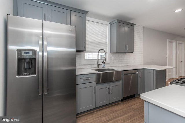 kitchen featuring gray cabinetry, dark hardwood / wood-style flooring, and stainless steel appliances