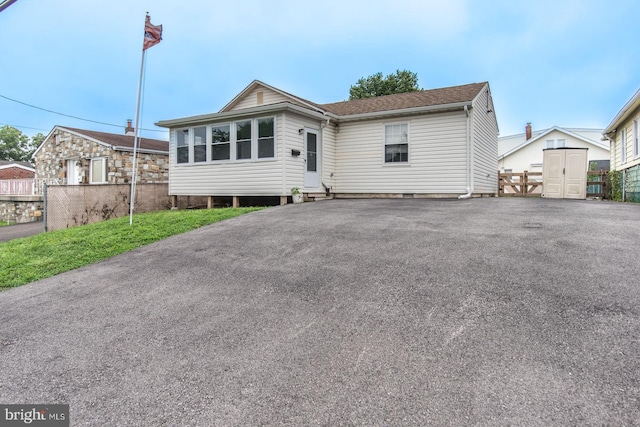 view of front of property featuring a shed