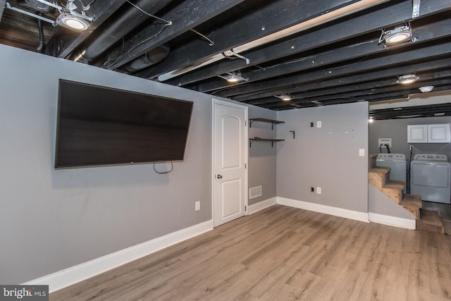 basement with hardwood / wood-style floors and independent washer and dryer