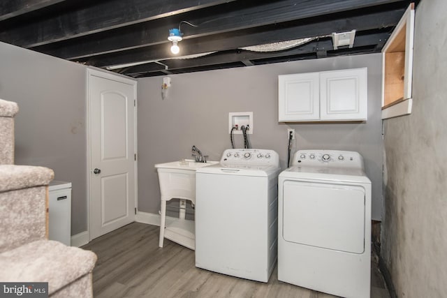 laundry room with cabinets, light hardwood / wood-style floors, and independent washer and dryer