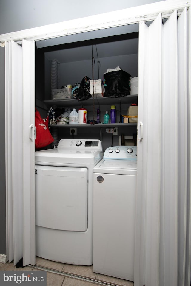 washroom featuring washing machine and dryer and light tile patterned flooring