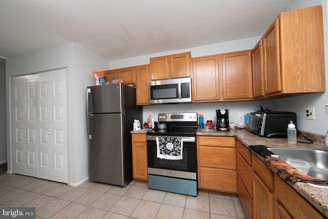 kitchen featuring appliances with stainless steel finishes and light tile patterned flooring