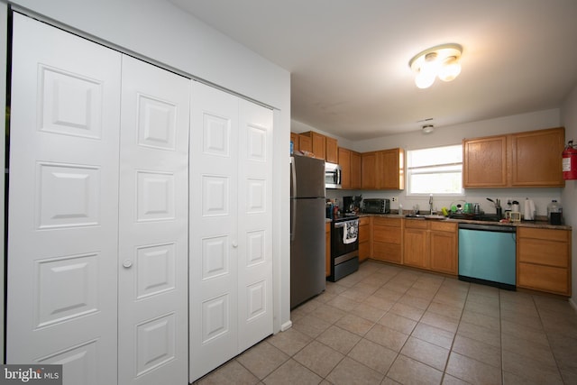 kitchen featuring appliances with stainless steel finishes, sink, and light tile patterned flooring