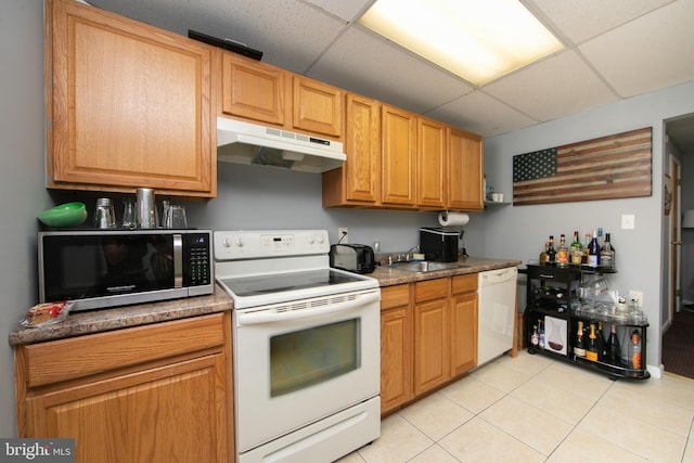 kitchen featuring white appliances, light tile patterned floors, sink, and a drop ceiling