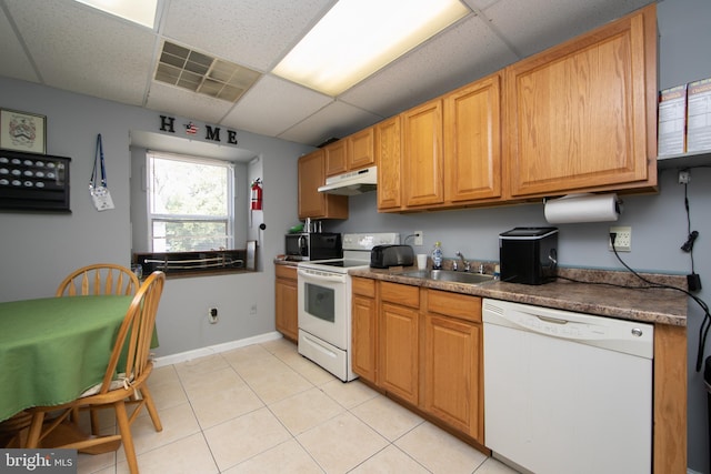 kitchen with light tile patterned floors, white appliances, a paneled ceiling, and sink