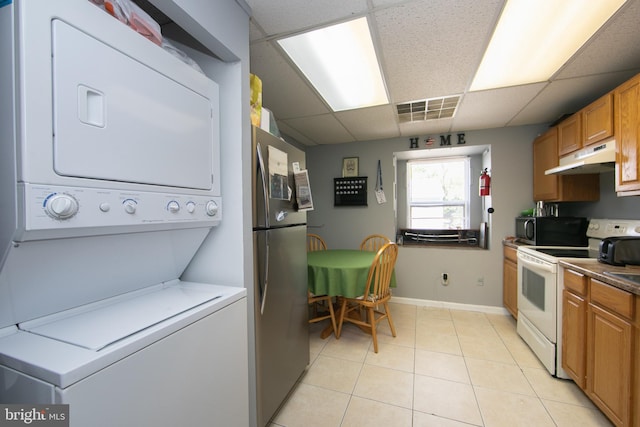 interior space featuring stacked washer and clothes dryer and light tile patterned floors