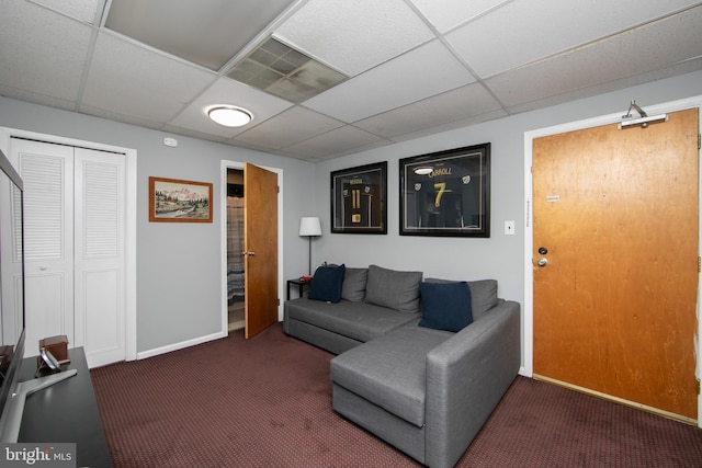 carpeted living room with a paneled ceiling