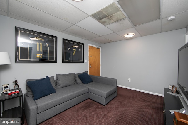 living room featuring carpet flooring and a drop ceiling