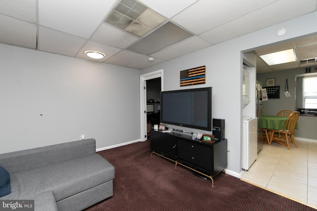 living room featuring a paneled ceiling and tile patterned floors