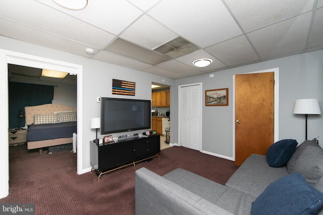 carpeted living room with a paneled ceiling