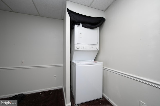 clothes washing area with stacked washing maching and dryer