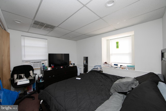 bedroom with a paneled ceiling and carpet