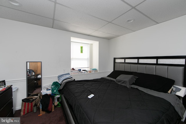 bedroom with a drop ceiling and carpet floors