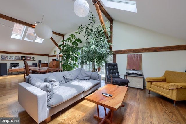 living room with a skylight, a wealth of natural light, wood-type flooring, and high vaulted ceiling