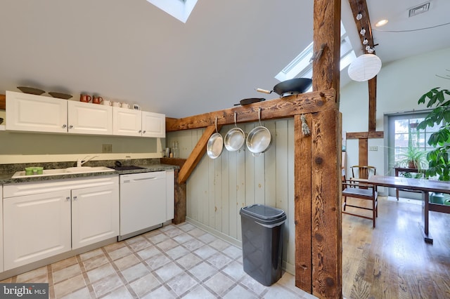 kitchen featuring light hardwood / wood-style floors, a skylight, white dishwasher, sink, and white cabinets