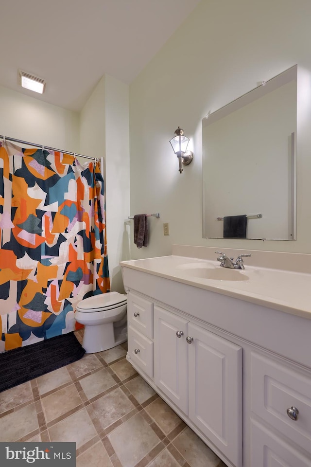 bathroom with vanity, tile patterned flooring, and toilet