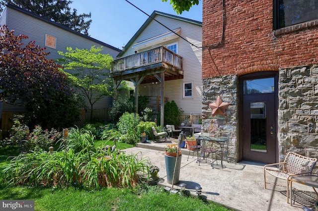 rear view of property featuring a patio area and a balcony