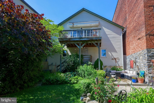 rear view of house with a balcony, an outdoor hangout area, and a patio