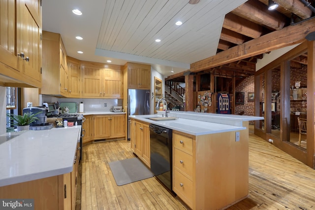 kitchen with black dishwasher, beam ceiling, brick wall, an island with sink, and sink