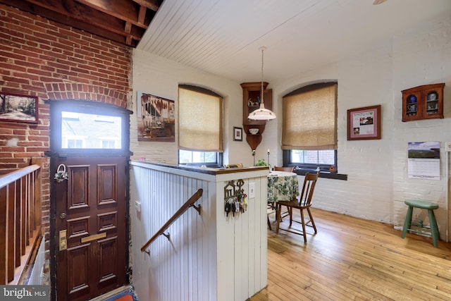 interior space featuring light hardwood / wood-style flooring, plenty of natural light, and brick wall