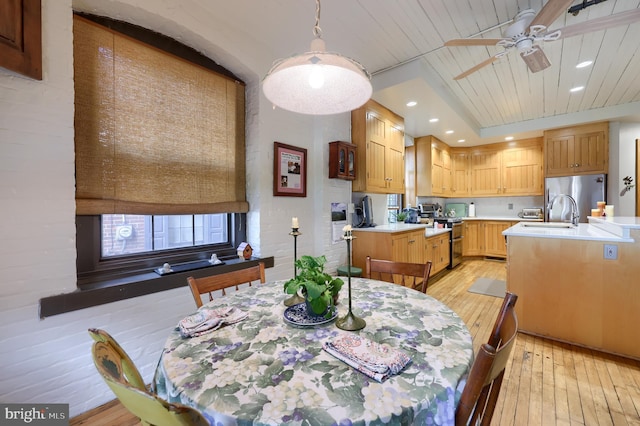 dining area with light hardwood / wood-style flooring, sink, and ceiling fan