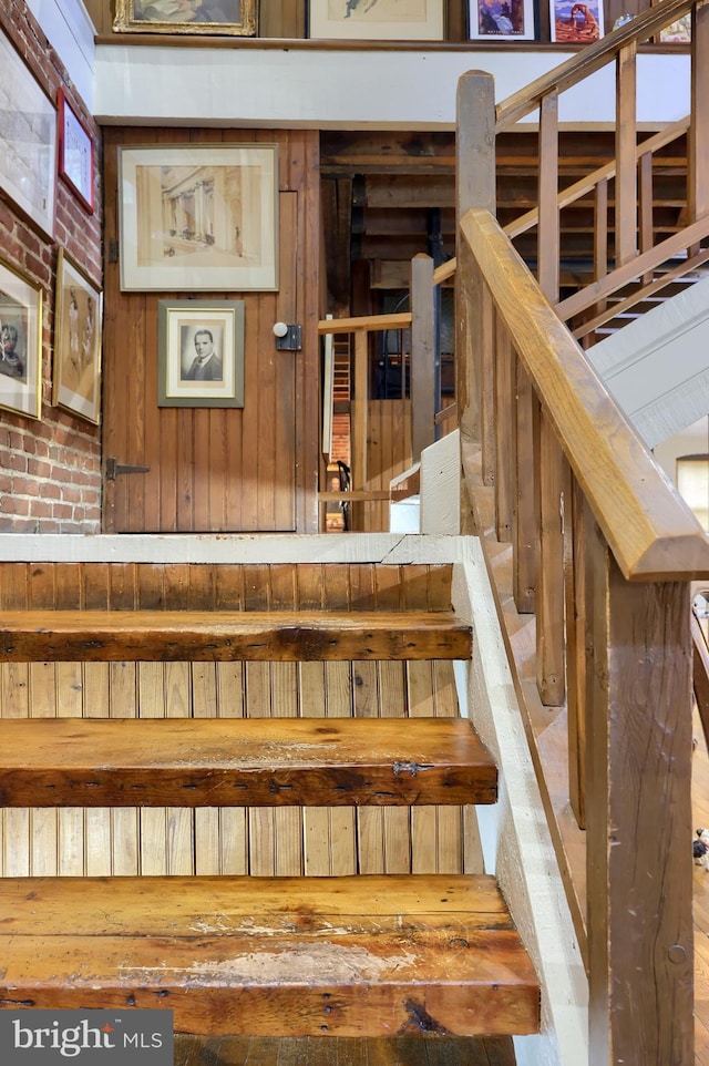 staircase featuring brick wall