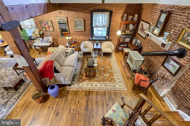 living room with hardwood / wood-style floors and brick wall