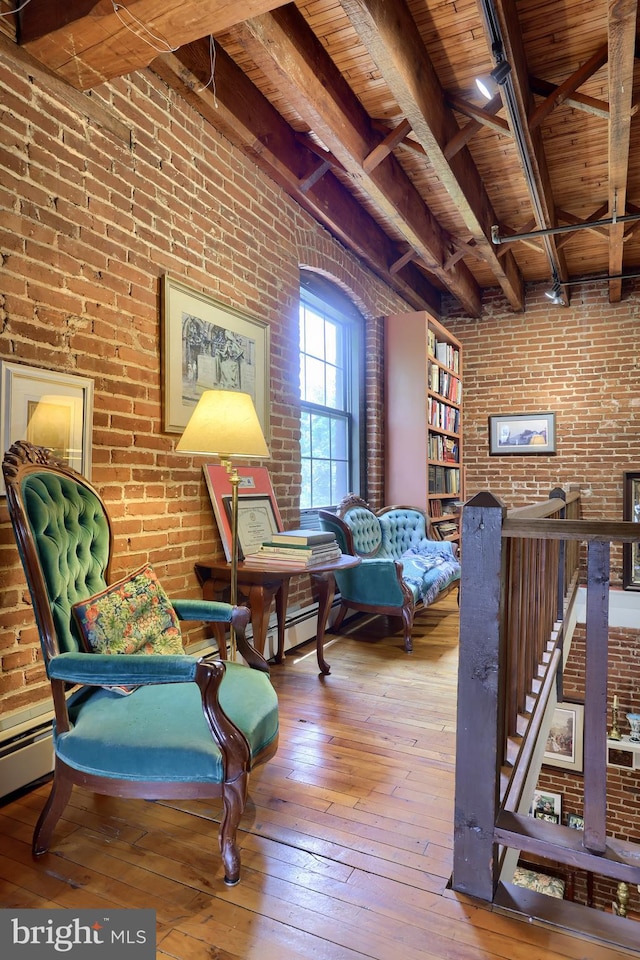 living area with wooden ceiling, brick wall, and wood-type flooring