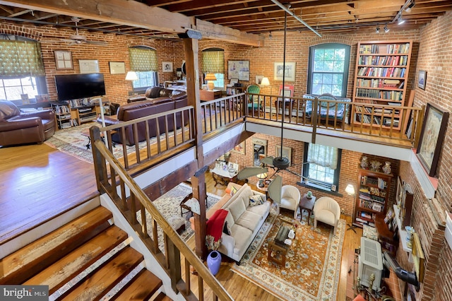 interior space featuring hardwood / wood-style floors, rail lighting, and brick wall