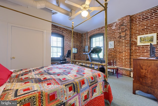 bedroom featuring ceiling fan, a high ceiling, brick wall, and carpet floors