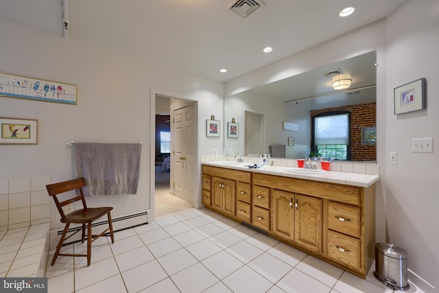 bathroom with brick wall, a baseboard radiator, double sink vanity, and tile patterned flooring