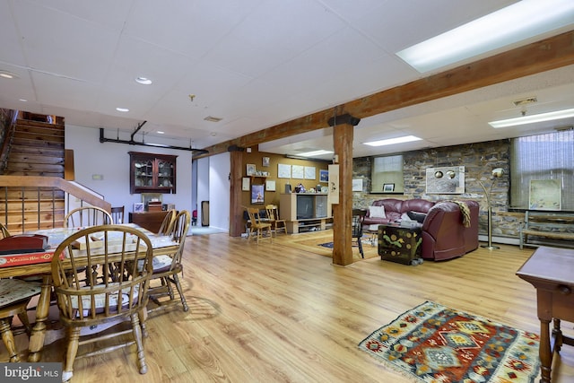 dining space with a drop ceiling and light hardwood / wood-style flooring