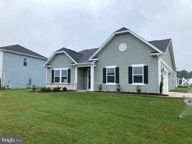 view of front facade featuring a front yard, central AC, and a garage