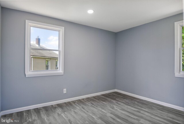 spare room featuring a wealth of natural light and hardwood / wood-style flooring