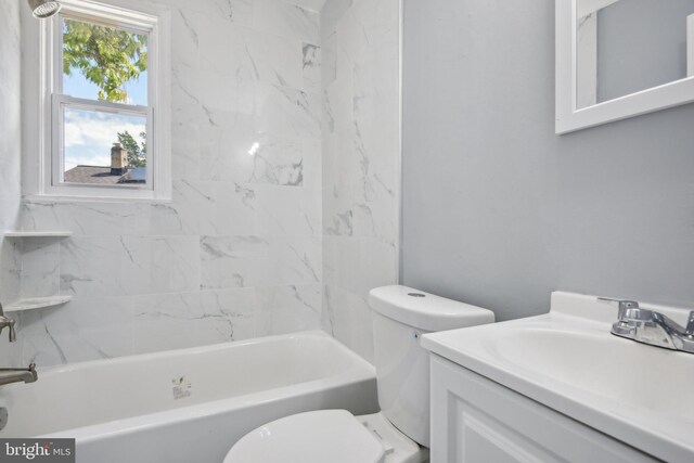 full bathroom featuring toilet, tiled shower / bath, and vanity