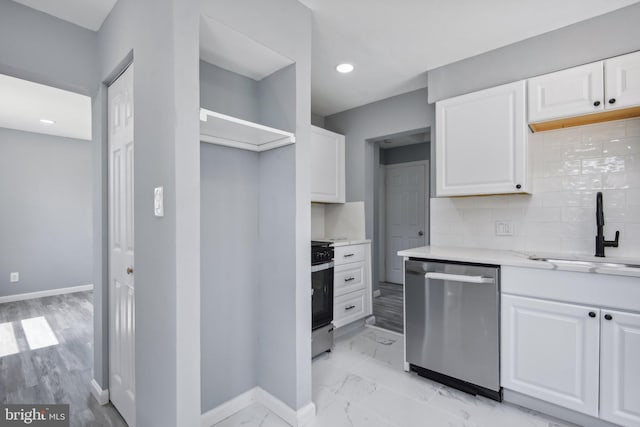 kitchen featuring backsplash, dishwasher, light hardwood / wood-style flooring, white cabinetry, and sink