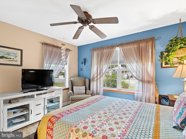 bedroom with hardwood / wood-style floors, multiple windows, and ceiling fan