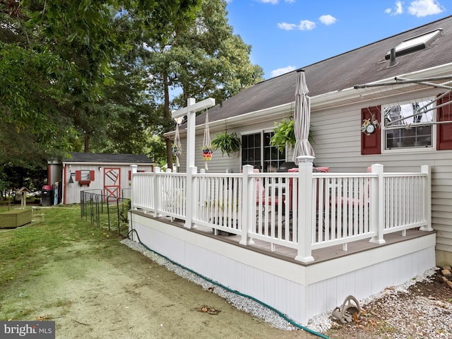 wooden terrace with a storage shed and a lawn