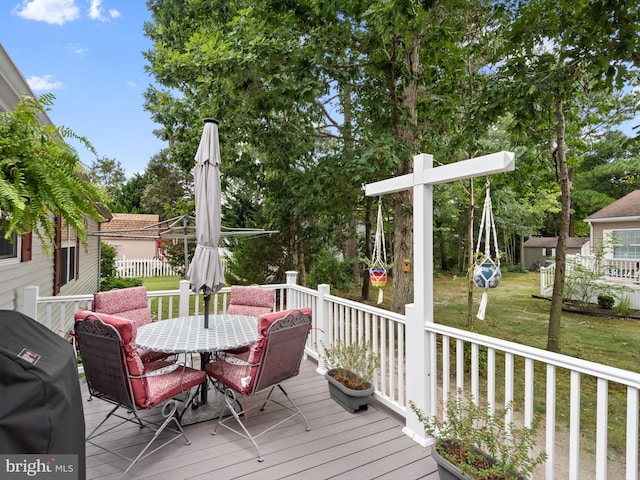 wooden deck with a lawn and area for grilling