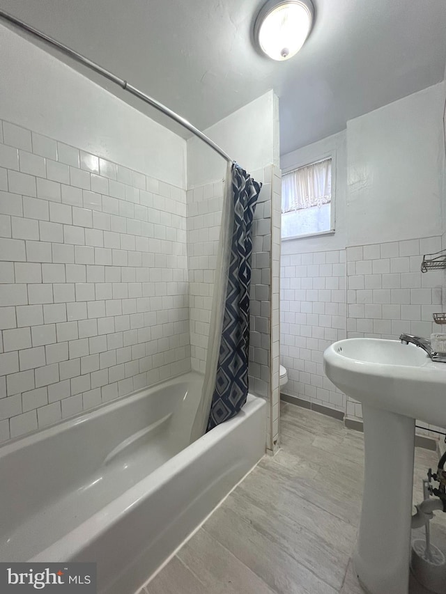 full bathroom with shower / tub combo with curtain, toilet, sink, tile walls, and hardwood / wood-style floors