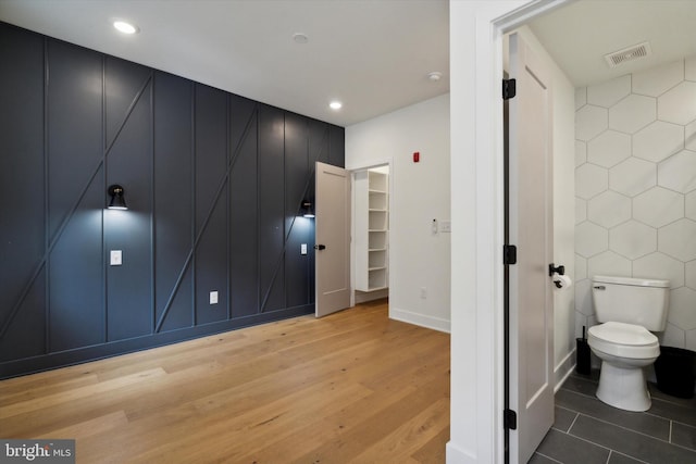 bathroom featuring wood-type flooring and toilet