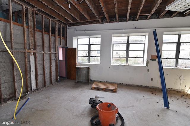 misc room with concrete flooring and radiator heating unit