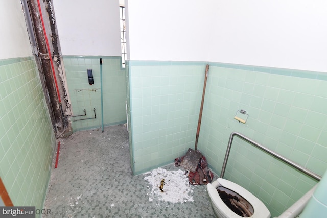 bathroom featuring tile walls and toilet