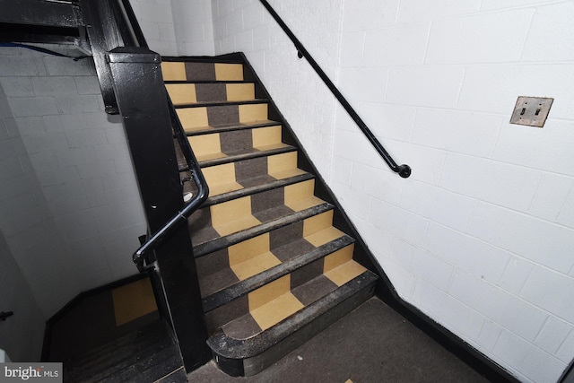 staircase featuring concrete flooring