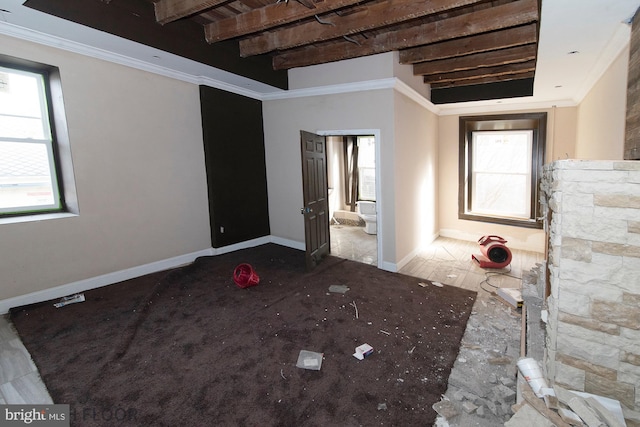 unfurnished room featuring ornamental molding, plenty of natural light, and beam ceiling