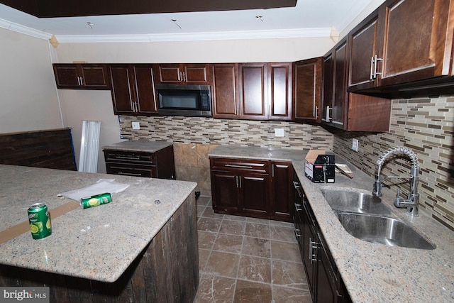 kitchen featuring tasteful backsplash, crown molding, light stone countertops, and sink