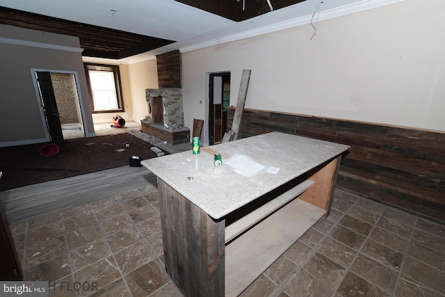 kitchen featuring crown molding, a fireplace, and a center island