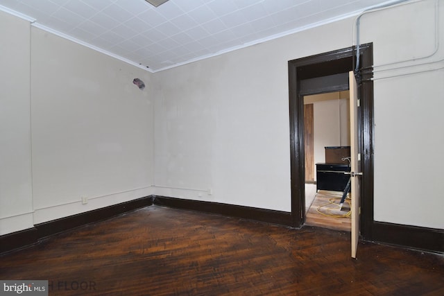 spare room with dark hardwood / wood-style flooring and crown molding