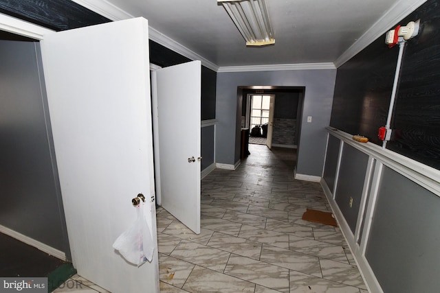 hall with ornamental molding and light tile patterned floors